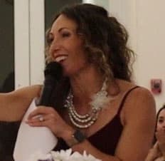 Auctioneer Brittany Trammell holding a microphone while hosting a fundraising event