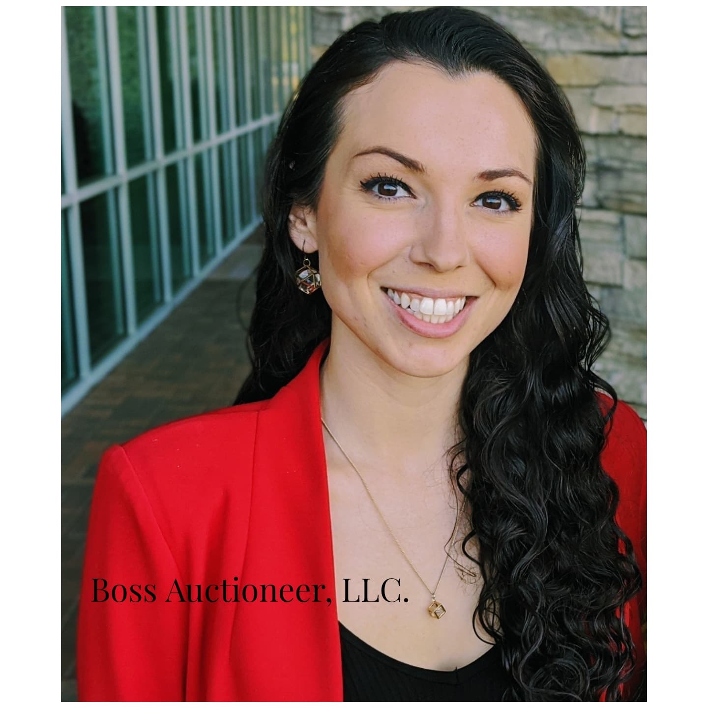 Portrait of auctioneer Nicole Cowan wearing a red blazer