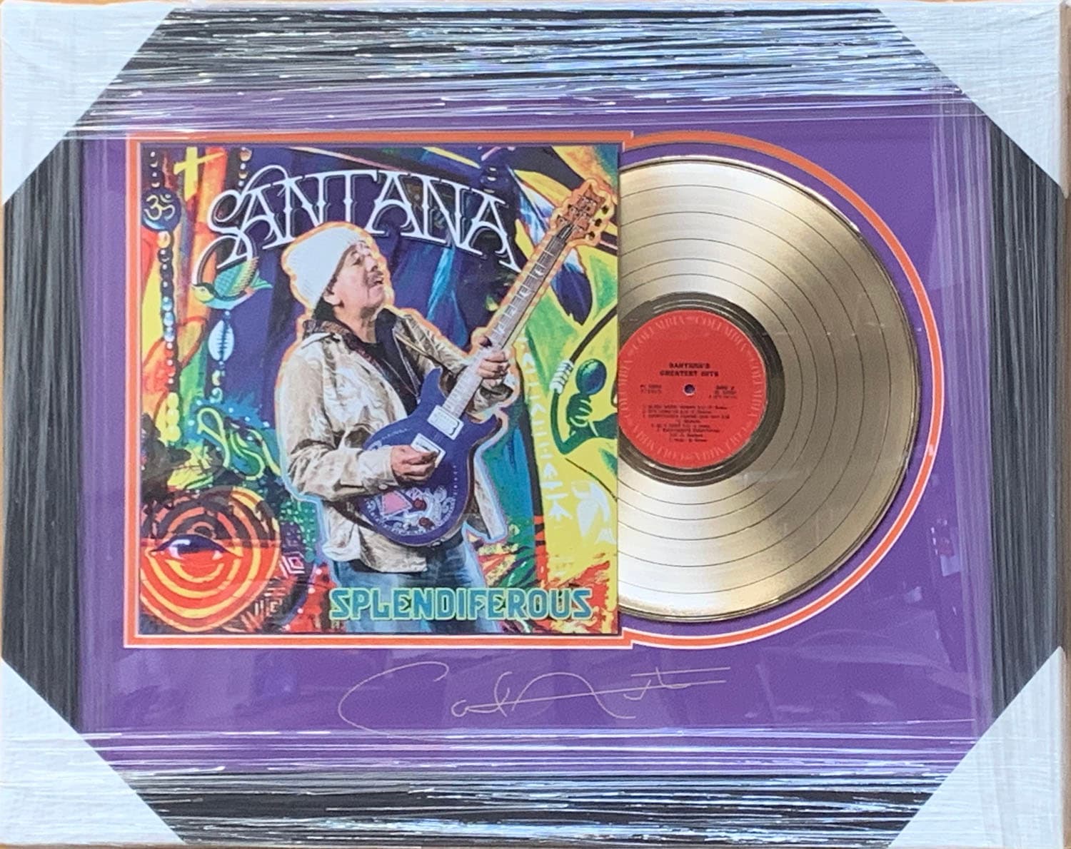 Framed gold record displayed beside the Carlos Santana Santana album cover with a laser-reproduced signature, offered as a charity auction lot