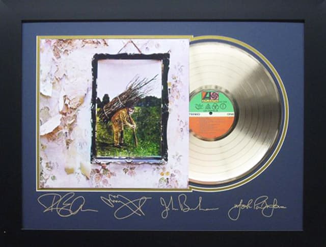 Framed gold record displayed beside the Led Zeppelin Houses of the Holy album cover with a laser-reproduced signature, offered as a charity auction lot