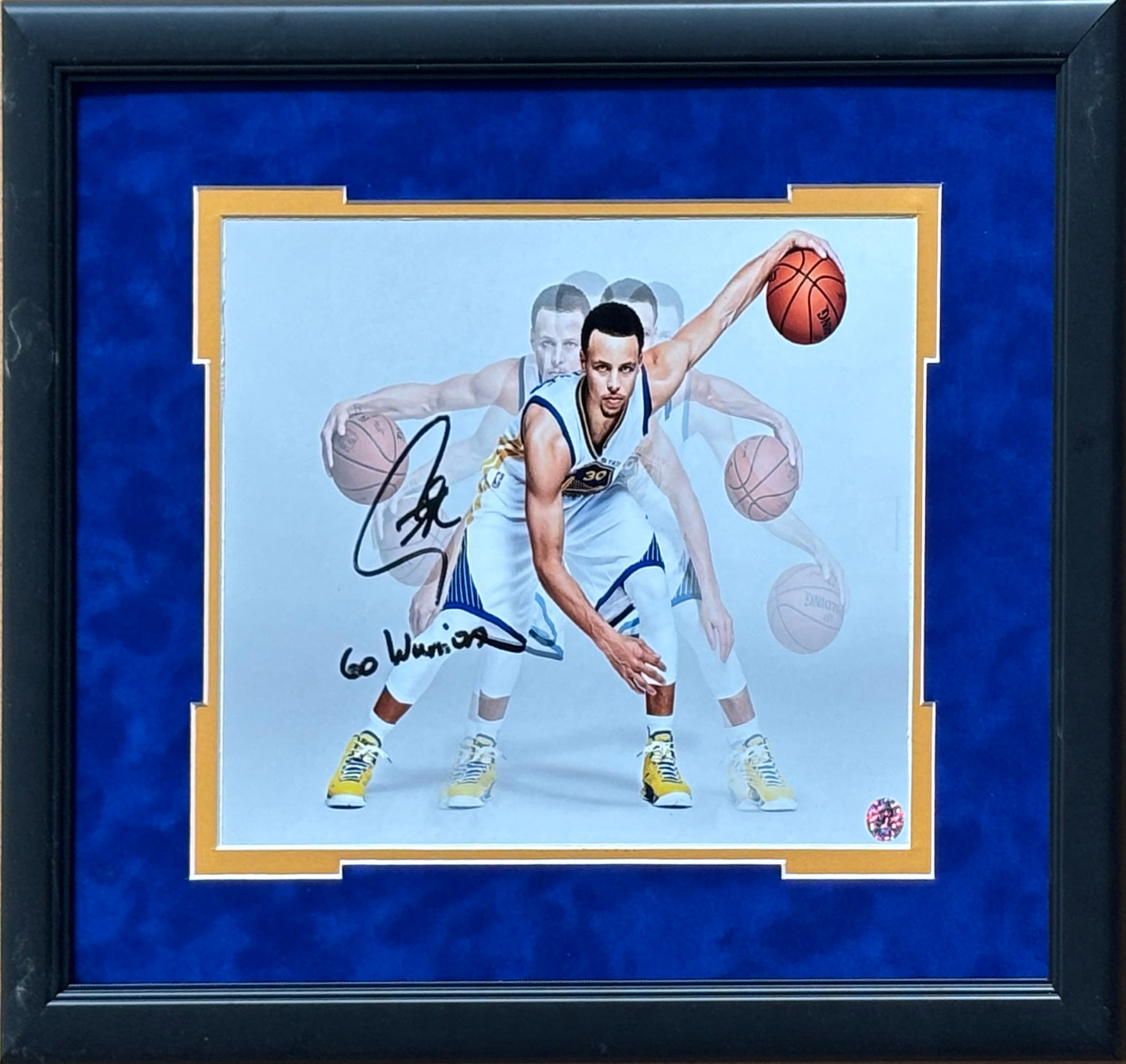 Framed Stephen Curry cross-over action print in a blue mount with reproduced signature, a charity auction lot