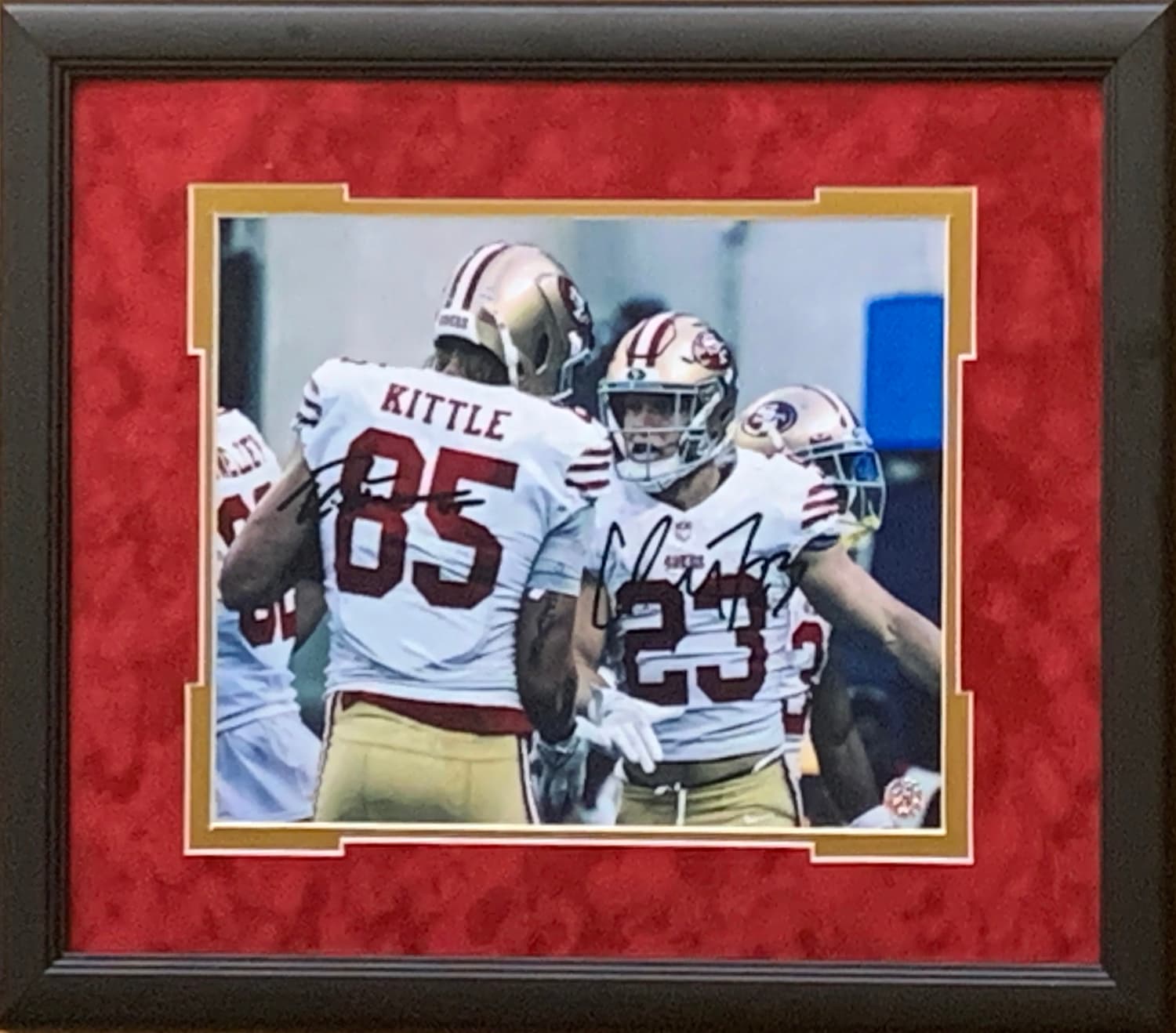 Framed 49ers duo 11 by 14 print of George Kittle and Christian McCaffrey with reproduced signatures, a charity auction lot