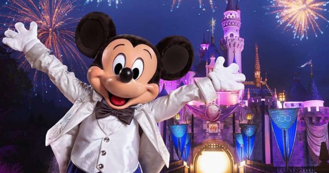 Mickey Mouse in front of the illuminated Disneyland castle, representing the Anaheim Disneyland auction package