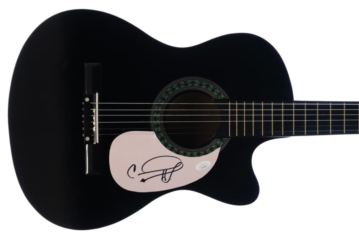 Black cutaway acoustic guitar hand-signed by Carrie Underwood on the pickguard, offered as a fundraiser auction item